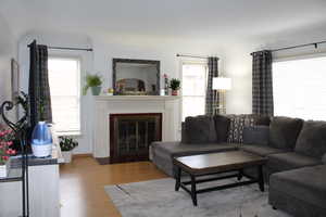 Spacious living room with lots of light, featuring a wood burning fireplace