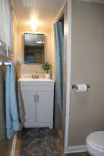 Bathroom featuring crown molding, vanity, and toilet