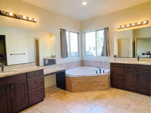 Bathroom with tiled tub and vanity