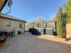 View of patio with a hot tub and central AC unit