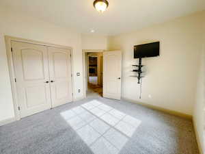 Unfurnished bedroom featuring light colored carpet and a closet