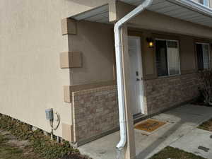 Property entrance featuring brick siding and stucco siding