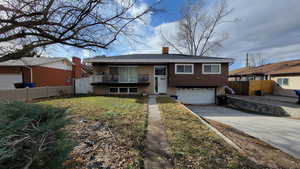 View of front of property featuring a garage and a front yard