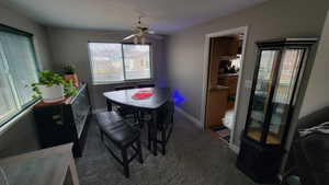 Carpeted dining space featuring ceiling fan