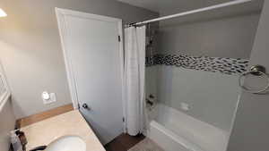 Bathroom featuring shower / bath combination with curtain and vanity