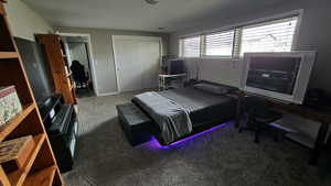 Bedroom with dark carpet and a closet