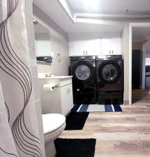 Interior space with hardwood / wood-style flooring and washing machine and dryer