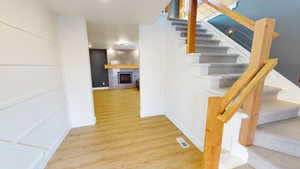 Stairs featuring hardwood / wood-style flooring and a tile fireplace