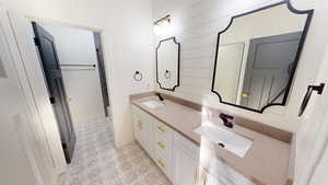 Bathroom with vanity and wood walls