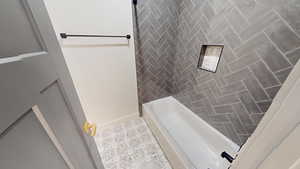 Bathroom with tile patterned flooring and shower / bathtub combination