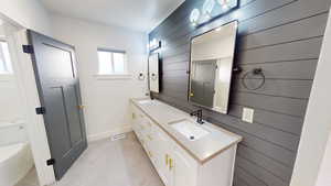 Bathroom featuring vanity, toilet, and wood walls