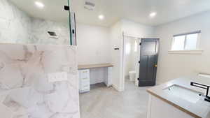 Bathroom with vanity, toilet, and a tile shower