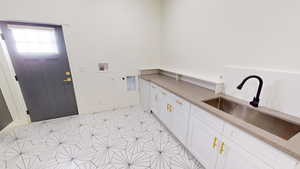 Clothes washing area with electric dryer hookup, sink, and hookup for a washing machine