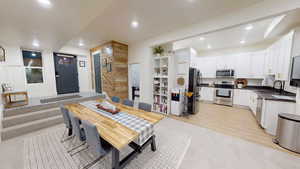 Dining room with sink and light wood-type flooring