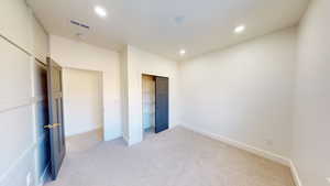 Unfurnished bedroom featuring a closet and light carpet