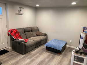 Living room with wood-type flooring and a textured ceiling