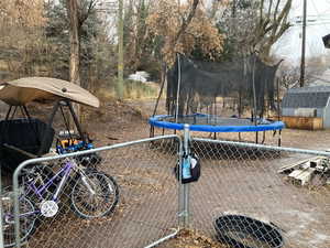 View of yard featuring a storage shed and a trampoline