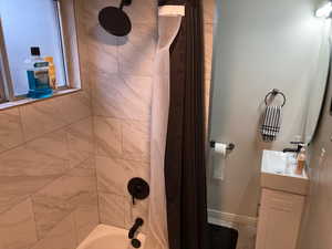 Bathroom with vanity and shower / bathtub combination with curtain