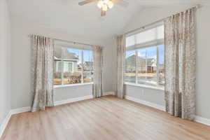 Unfurnished room featuring ceiling fan, vaulted ceiling, and light hardwood / wood-style flooring