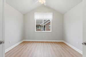 Additional living space with ceiling fan, lofted ceiling, and light hardwood / wood-style floors