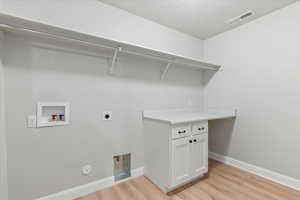 Laundry area featuring hookup for a gas dryer, electric dryer hookup, washer hookup, and light hardwood / wood-style floors