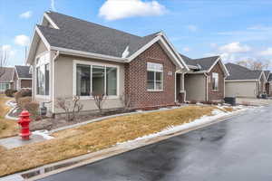 View of front of house with a front yard and central AC unit