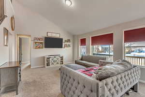 Living room with lofted ceiling and light carpet