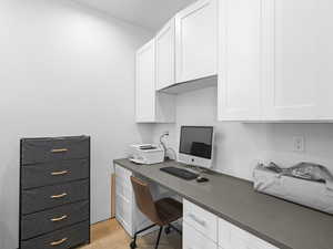 Office area featuring built in desk and light hardwood / wood-style floors