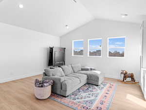 Upstairs family room featuring vaulted ceiling and light wood-type flooring