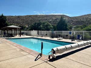 View of community swimming pool with a mountain view, a gazebo, and a patio area