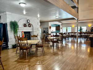 Clubhouse dining space with a fireplace, hardwood / wood-style floors, and a textured ceiling