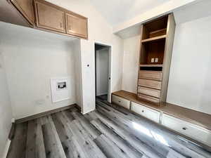 Interior space with cabinets, washer hookup, and light hardwood / wood-style floors