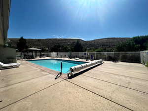 View of community pool with a gazebo, a mountain view, and a patio area