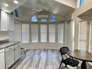 Interior space featuring dishwasher, ceiling fan, light stone countertops, light hardwood / wood-style floors, and white cabinets