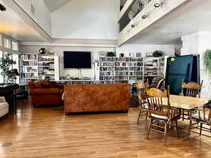 Living room featuring light hardwood / wood-style floors, a textured ceiling, and a high ceiling