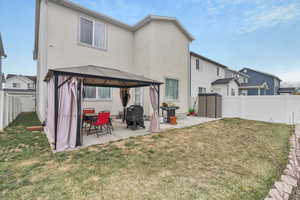 Back of house featuring a gazebo, patio and fully landscaped & fenced.