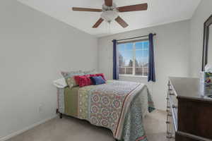 Carpeted bedroom featuring ceiling fan