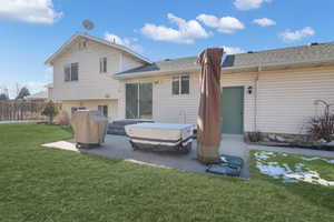 Rear view of property featuring a patio area and a lawn