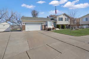 Split level home with a garage and a front lawn