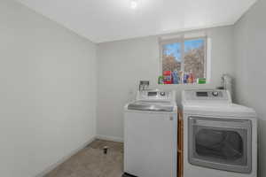 Laundry room featuring independent washer and dryer and light tile patterned floors