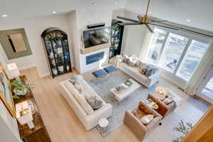 Living room featuring light wood-type flooring, a fireplace, and vaulted ceiling