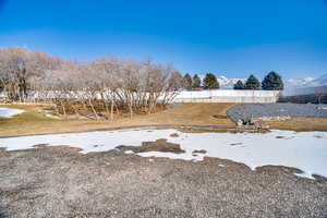 Yard layered in snow with a mountain view