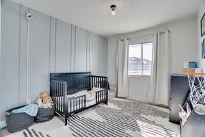 Bedroom with a nursery area and a textured ceiling