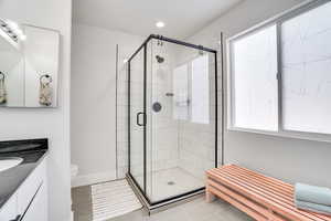 Bathroom with vanity, an enclosed shower, and toilet