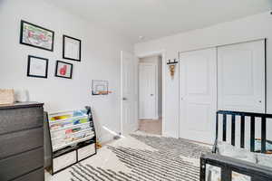 Carpeted bedroom with a closet and a textured ceiling