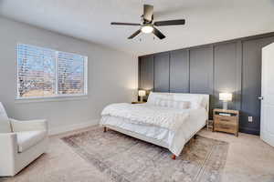 Bedroom featuring ceiling fan, light colored carpet, and a textured ceiling