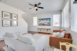 Living room with dark wood-type flooring and ceiling fan