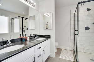 Bathroom with vanity, an enclosed shower, and toilet