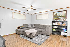 Living room with crown molding, light hardwood / wood-style flooring, and ceiling fan