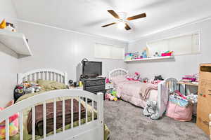 Bedroom featuring crown molding, a textured ceiling, carpet floors, and ceiling fan